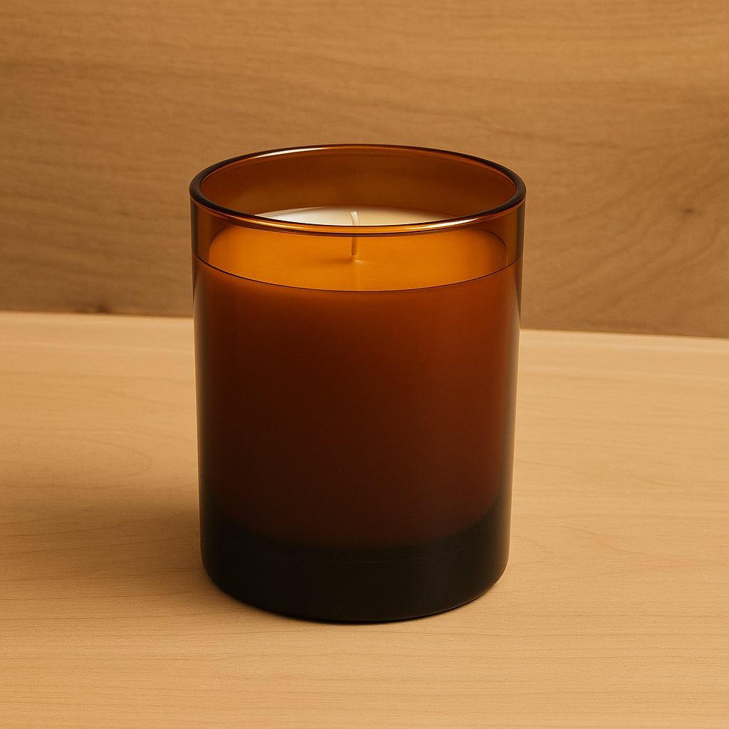 Schlichtes Produktbild. Ein elegantes Kerzenglas in amber steht auf einer Holzplatte. Die Beleuchtung ist hell und freundlich und strahlt Wärme aus.